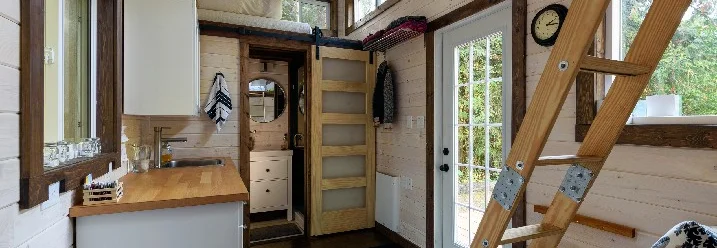 Innenraum eines Tiny Houses mit Holzleiter